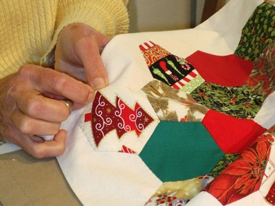 Hands sewing a quilt